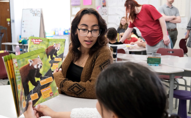 Female student teacher reading to students