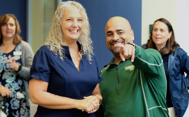 smiling and pointing employees at welcome back