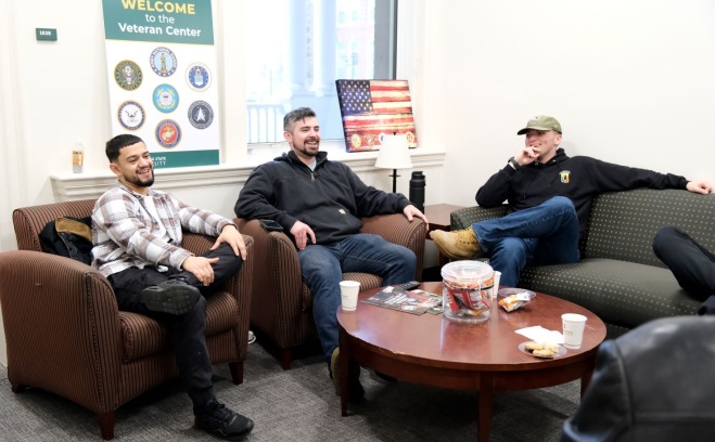 Male students sitting and laughing in the Veterans Center
