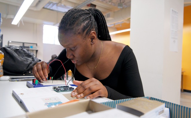 Student working on electronics at table in classroom 