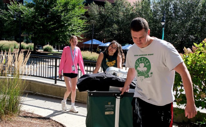 Students pushing bins and carrying gear moving into Aubuchon Hall
