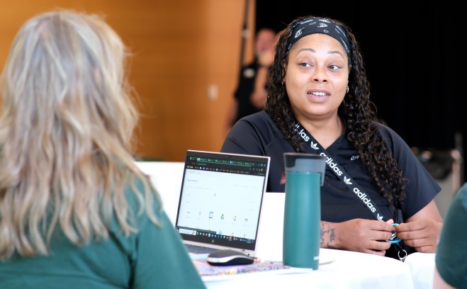 Counselor advising student at table with laptop