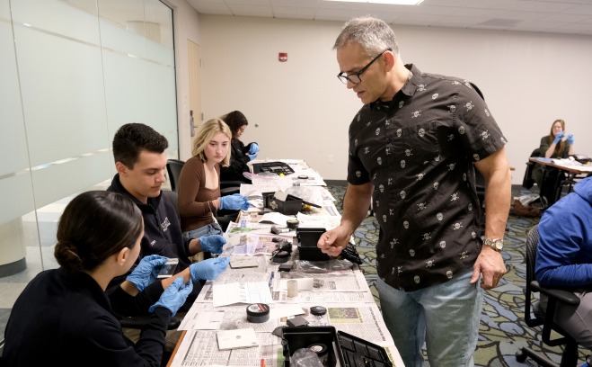 Students working with fingerprinting equipment in CJ class