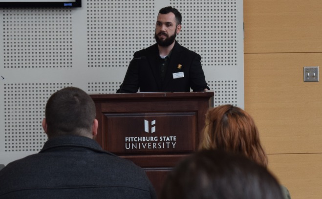 Nolan Buck speaking at the podium in main lounge of Hammond