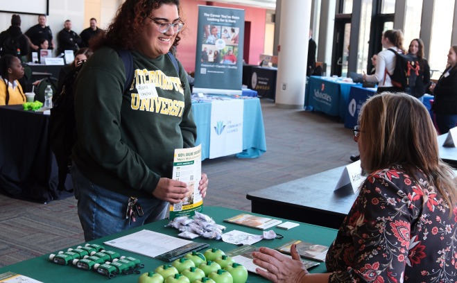 Student talking to SGOCE at table at career fair