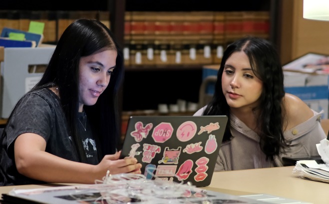 Female twins in the archives on their laptops