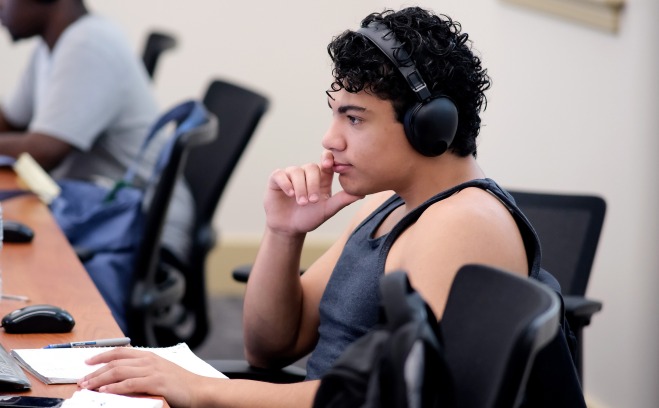 Male student with headphones at computer