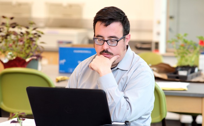 Older male student on laptop in classroom