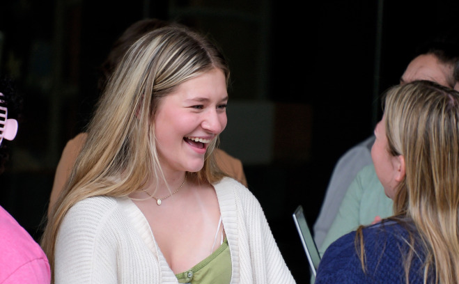 Students talking and smiling outside.