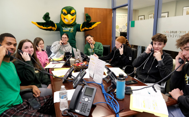 Freddy and sport team volunteers calling donors for Go Falcon Challenge.
