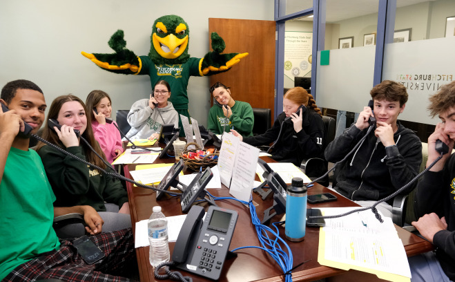 Freddy and sport team volunteers calling donors for Go Falcon Challenge.