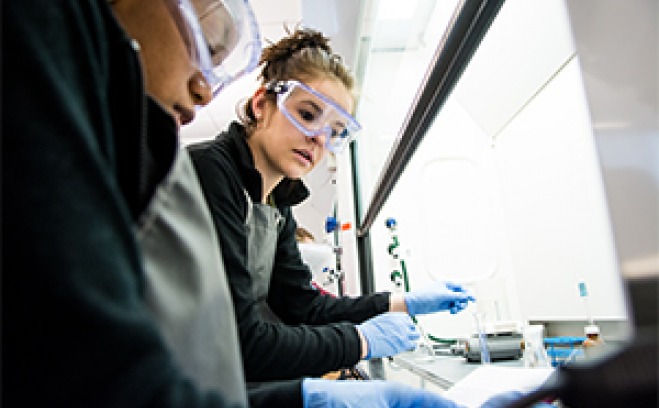 Students wearing safety goggles working in a lab