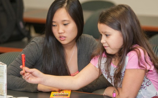 College student teaching a young girl