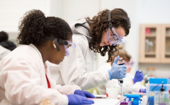 students in lab with goggles and gloves working with chemicals
