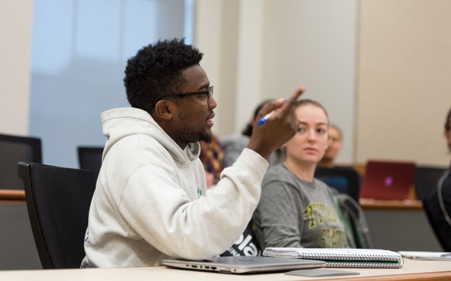two students talking in a classroom 