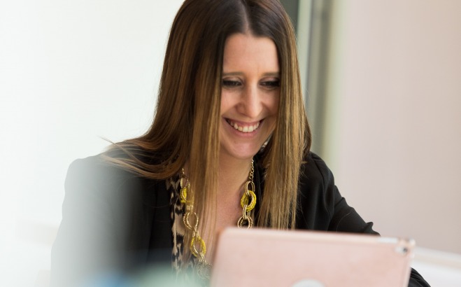 smiling student looks at her laptop