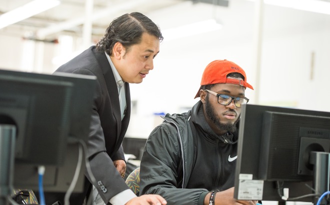 Engineering professor and student at computer in classroom
