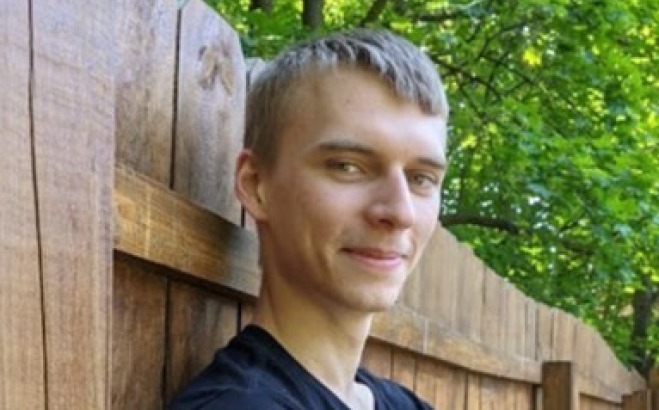 Kurtis Kendall Professional Writing Student headshot leaning against a fence