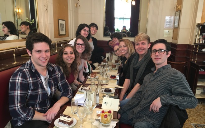 Students posing at table eating dinner in Paris on study abroad trip