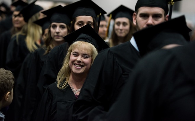 Male and female graduate students entering for commencement ceremony
