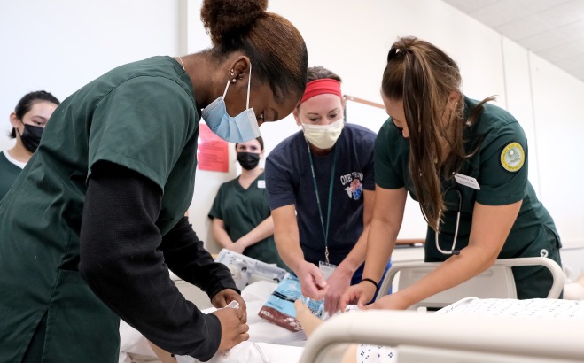 Nursing students and instructor working on patient during a catheter lab
