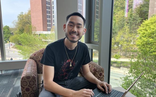 Student on laptop studying in Hammond with Aubuchon Hall in background