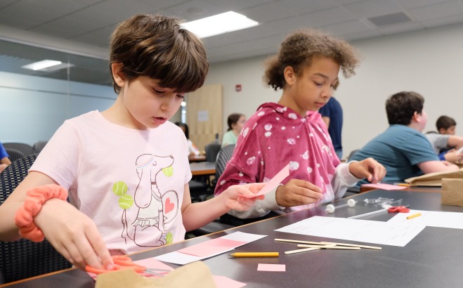 Two female McKay students working at table in the classroom