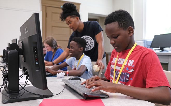 Upward bound students at computers with teacher
