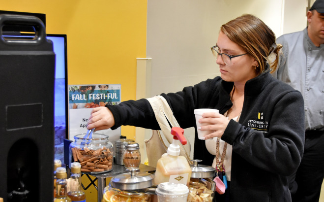 Female student getting beverage in Holmes during fall fest