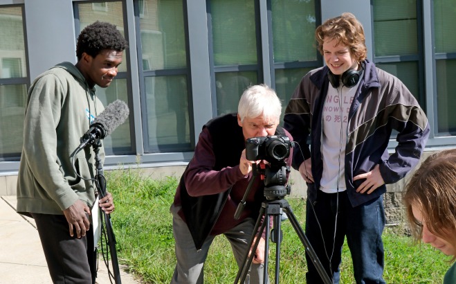 Film and Video students with instructor looking through camera with microphone