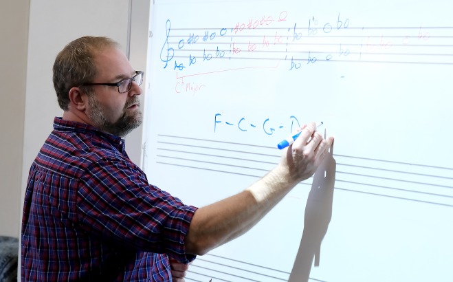 Justin Casinghino Music Professor writing music on white board