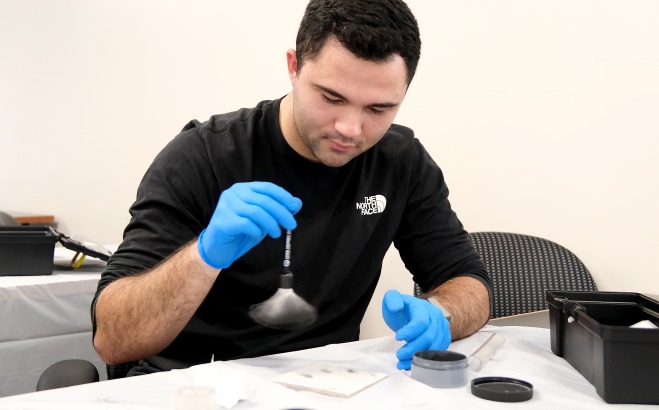 Student dusting for prints in CJ fingerprint lab