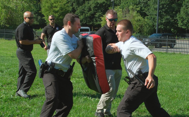 Police program candidates in combat training after being pepper sprayed with instructors
