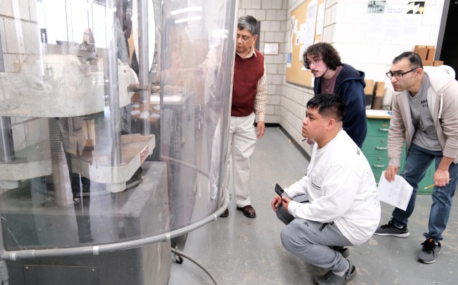 teacher and students in machine shop observing machine