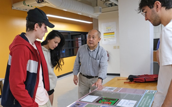 Professor talking with students in an Engineering Technology classroom