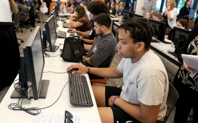Tables of students all working at desktop computers