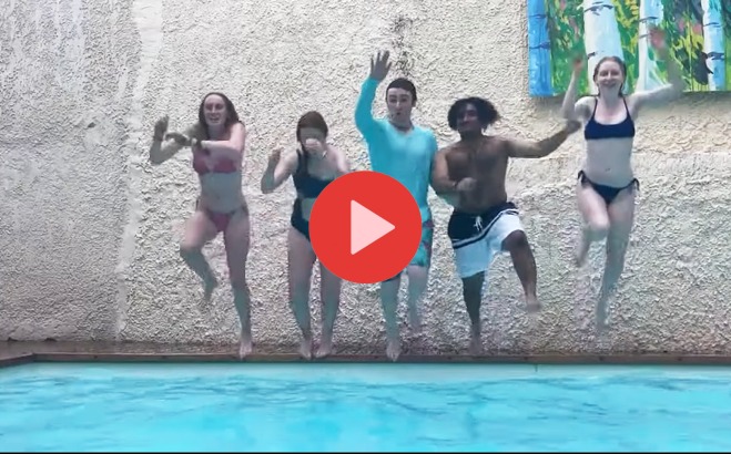 Students jumping in pool in Greece with video play button over it