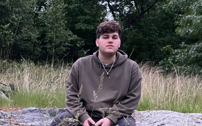 Jordan Wasil ACT tutor outside sitting on a rock