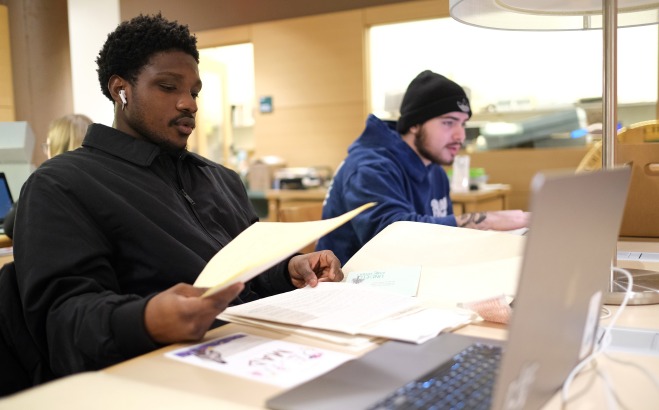 Two male students working on computers in the archives