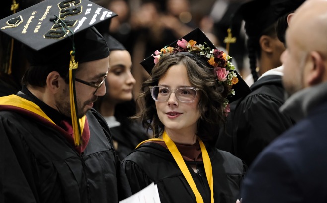Graduate looking at name card and gradate looking at them