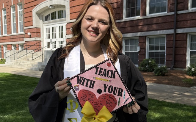 Mallory Judkins with cap and in gown on quad