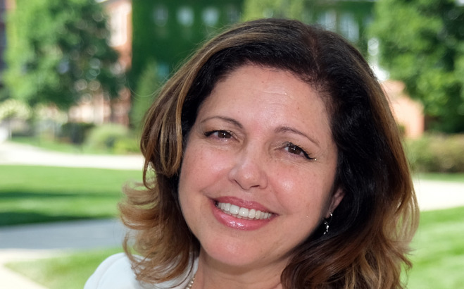 Ana Mesquita-Emlinger, headshot outside on campus.