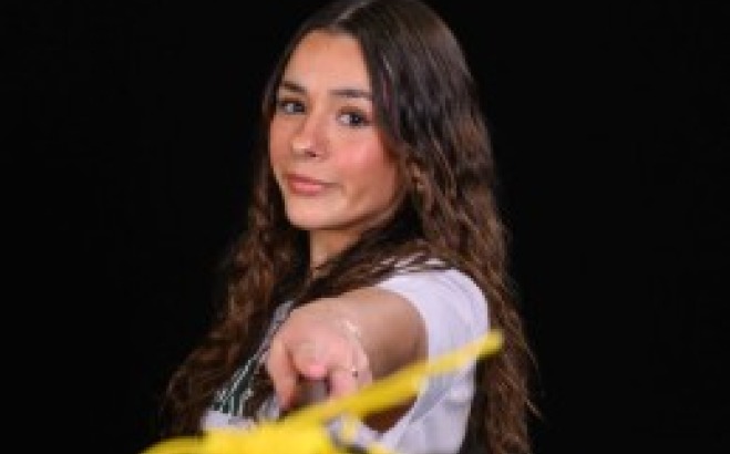 Mykaela Correira ACT athletic tutor in her lacrosse uniform with her lacrosse stick .