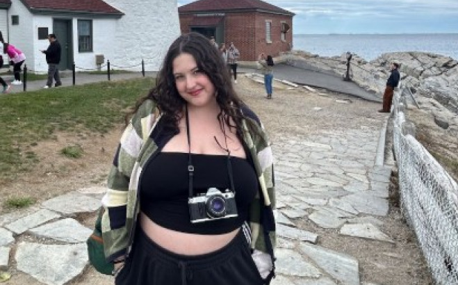 Livv Welch outside by a lighthouse and the ocean.