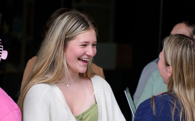 Students talking and smiling outside.