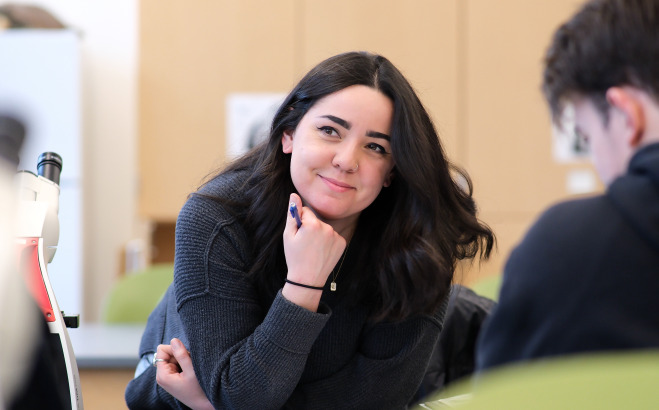 Smiling female student at table in lab.