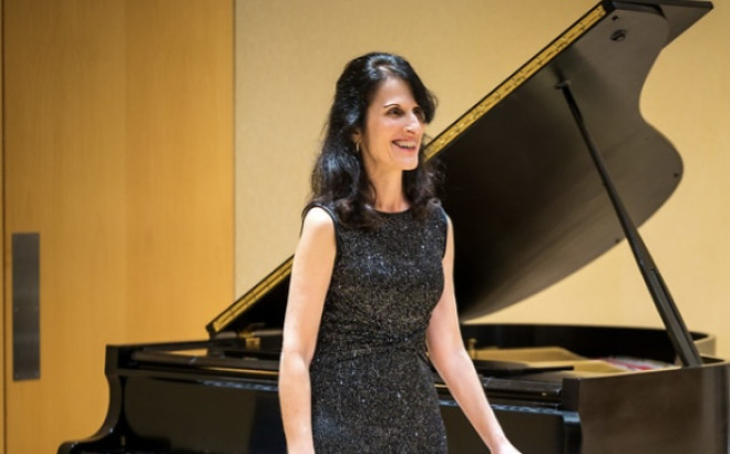 Alanna Rantala community music instructor standing by a piano.