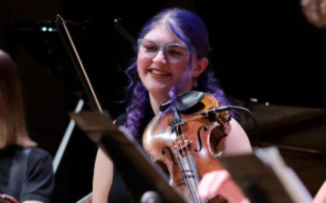 Grace Mita ACT with violin on stage.