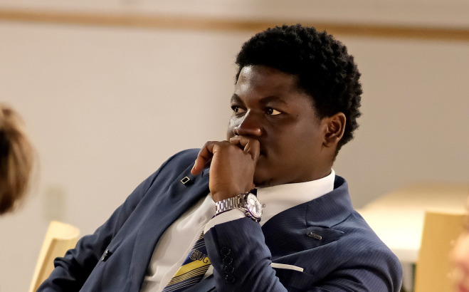 Focused student in suit in Falcon Hub.
