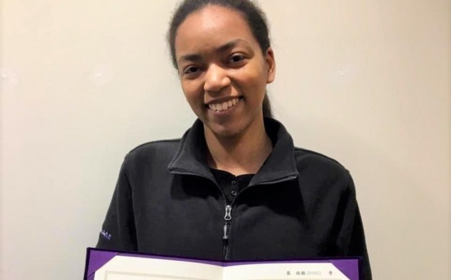 Imani Hunter with a certificate from Reitaku University